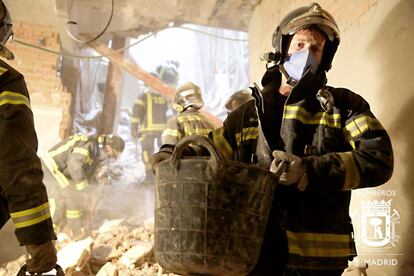 Un bombero retira escombros a mano.