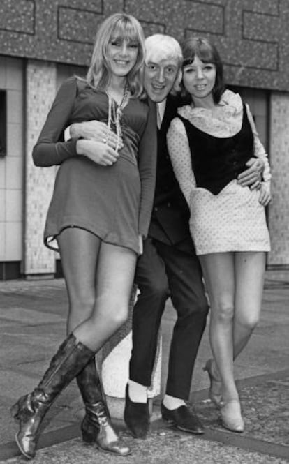 Jimmy Savile, junto a dos concursantes de un programa de televisión, en Londres, en 1968.