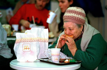 Una mujer come una hamburguesa en el primer McDonald's que abrió en Rusia, en Moscú, el 31 de enero de 1990.