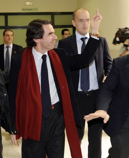 Pese a la timidez que evidencia su gesto arrogante (es una forma de defenderse), Aznar nunca le ha hecho ascos a un poco de teatralidad indumentaria. Aquí, en el aciago día que fue a dar una charla a la Universidad de Oviedo y algunos alumnos le increparon: la peineta habría quedado muy deslucida si su perfecto 'look' a la inglesa hubiera estado desprovisto del elegante movimiento de su finísima bufanda burdeos.