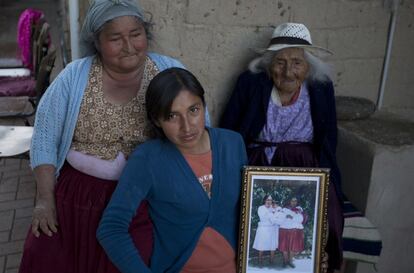 La supercentenaria, como se conoce a los ancianos que superan los 100 años, posa junto con su sobrina-nieta Agustina Berna (izquierda), y su sobrina bisnieta Rosa Lucas (centro) mostrando una fotografía de las tres hace más de veinte años.