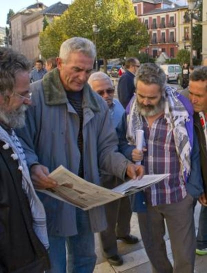 El diputado andaluz de IU Juan Manuel Sánchez Gordillo (d) y el portavoz del Sindicato Andaluz de Trabajadores (SAT), Diego Cañamero (2i), leen la prensa junto a otros jornaleros ante la sede del Tribunal Superior de Justicia de Andalucía (TSJA) en Granada, donde el pasado 12 de noviembre prosiguió el juicio por la ocupación de la finca militar "Las Turquillas". EFE/Archivo