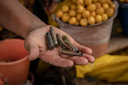 Una vendedora de frutas muestra los casquillos que quedaron al interior del mercado norte después del enfrentamiento de grupos armados.