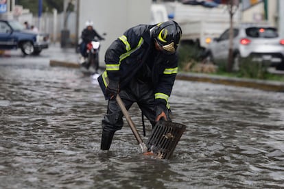 Un bombero intenta destapar una coladera en Ciudad de México, en julio de 2024. 