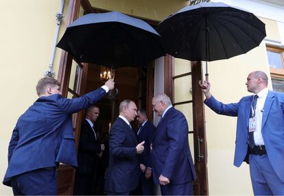 Putin y Lukashenko, resguardados bajo paraguas, en San Petersburgo en julio de 2019. (