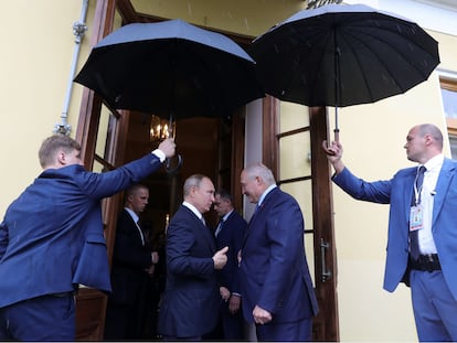 Putin y Lukashenko, resguardados bajo paraguas, en San Petersburgo en julio de 2019. (