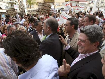 Federico Trillo, detrás de Francisco Camps, hace una peineta a la salida de un acto en Torrevieja.