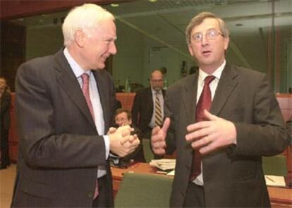 El presidente del Banco Europeo de Inversión, Philippe Maystadt (a la izquierda) habla con Jean-Claude Juncker.