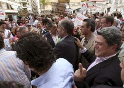 El diputado del PP Federico Trillo (d), detrás del presidente de la Generalitat Valenciana, Francisco Camps, reacciona tras ser increpados por simpatizantes del movimiento