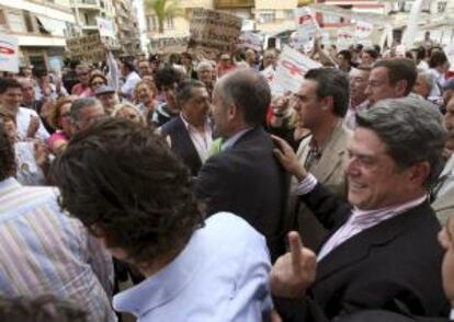 El diputado del PP Federico Trillo (d), detrás del presidente de la Generalitat Valenciana, Francisco Camps, reacciona tras ser increpados por simpatizantes del movimiento