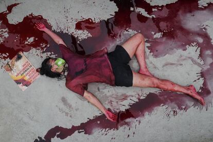Una activista permanece en el suelo cubierta con sangre ficticia, durante una protesta contra la destrucción del medio ambiente en Yakarta (Indonesia).