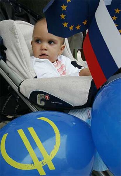 Un bebé con las banderas de la UE y Eslovenia y el símbolo del euro.