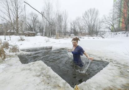 Una creyente ortodoxa se baña en agua helada durante las celebraciones por la festividad de la Epifanía, en Kiev (Ucrania).