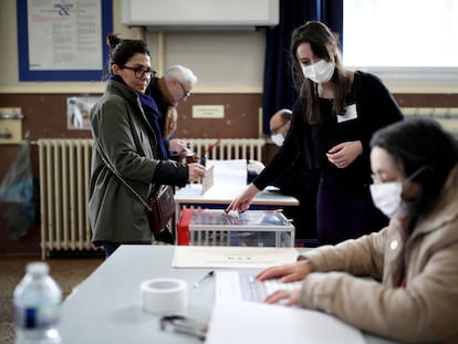 Varias personas con mascarillas, este domingo, en un colegio electoral de París.