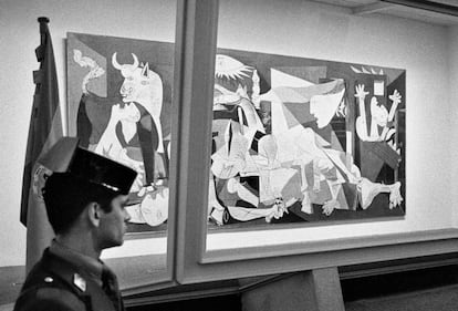 Un agente de la Guardia Civil vigila la urna blindada que protege el 'Guernica', obra de Pablo Picasso, en su presentación en el emplazamiento del Casón del Buen Retiro de Madrid, tras su llegada a España en 1981.