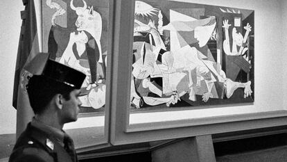Un agente de la Guardia Civil vigila la urna blindada que protege el 'Guernica', obra de Pablo Picasso, en su presentación en el emplazamiento del Casón del Buen Retiro de Madrid, tras su llegada a España en 1981.