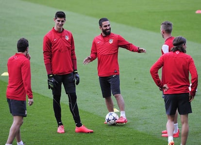 Courtois y Arda Turan, junto a otros compañeros, durante la sesión de entrenamiento previa al choque de cuartos de final de la Champions ante el Barcelona.