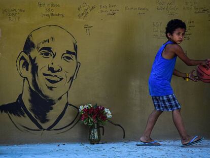 Un niño junto a un retrato de Kobe Bryant, en Manila.
