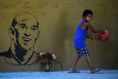 Un niño junto a un retrato de Kobe Bryant, en Manila.