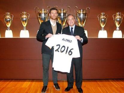 Xabi Alonso posa con Florentino después de la firma