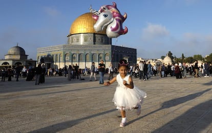 Una niña corre con un globo de helio frente a la Cúpula de la Roca de la ciudad de Jerusalén, el 21 de agosto de 2018. 