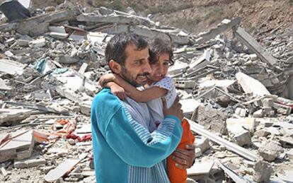 Un palestino contempla con su hija en brazos su casa derribada por el Ejército israelí ayer en Nablús.