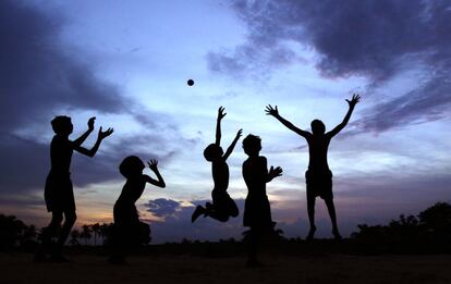 Unos niños juegan al atardecer en las afueras de la ciudad de Bhubaneswar, India, 20 de junio de 2013.