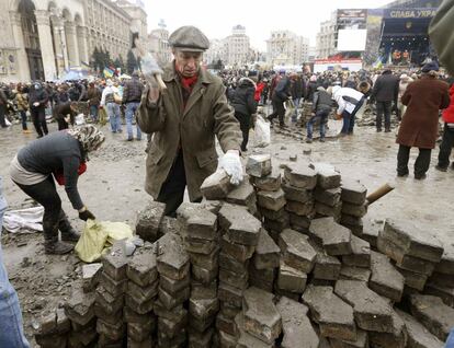 Manifestantes antigubernamentales preparan piedras.