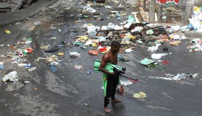 Um homem caminha por uma rua suja de Copacabana.