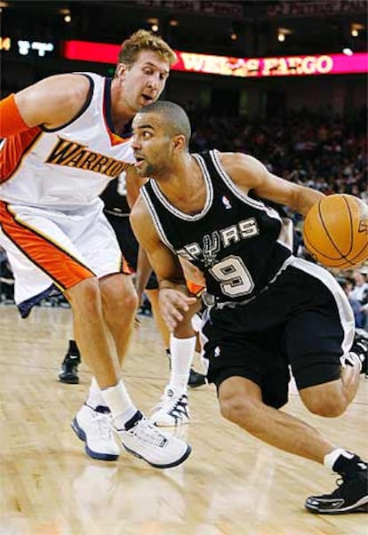 Tony Parker, de los Spurs, dribla a Troy Murphy, de los Golden State Warriors.