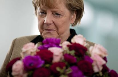 La canciller alemana recibe un ramo de flores en Berlín.
