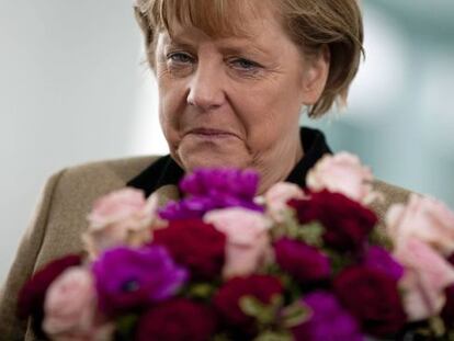 La canciller alemana recibe un ramo de flores en Berlín.