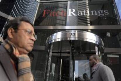 Dos viandantes pasan frente a la entrada de la sede de la agencia de calificacin Fitch en Nueva York, EE.UU.