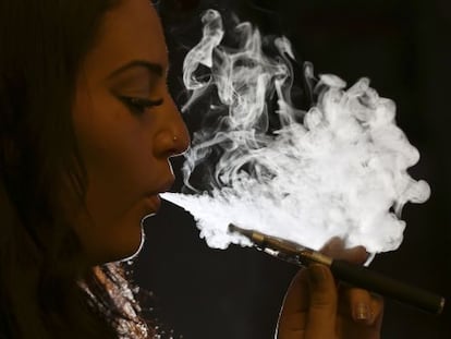 Uma mulher fuma um cigarro eletrônico