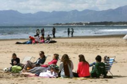 Varias personas intentan tomar el sol en la Playa de Levante de Salou (Tarragona), durante esta Semana Santa. EFE/Archivo