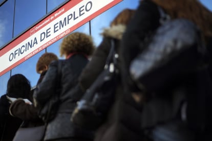 Women stand in line outside an unemployment office.