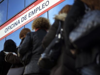 Women stand in line outside an unemployment office.