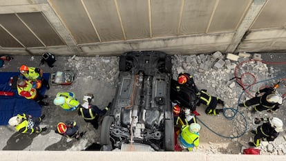 El vehículo encajado entre los muros de entrada al parking subterráneo tras caer desde ocho metros de altura.