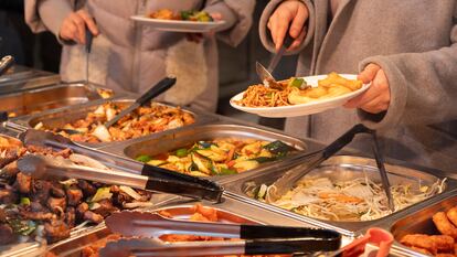 Dos personas se sirven comida en un restaurante chino de Londres.