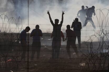 Manifestantes palestinos se cubren del gas lacrimógeno lanzado por soldados israelíes hacia los territorios palestinos en la frontera, al sur de Israel, el 8 de junio.