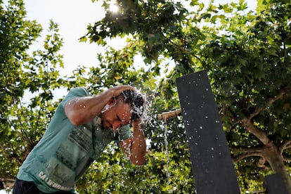 Una persona se refresca en una fuente de la Plaza del Castillo, en Pamplona, en los primeros días de esta larga ola de calor en España.