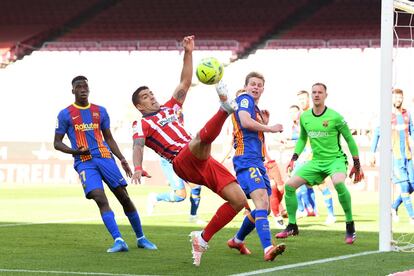 Luis Suárez del Atlético de Madrid intenta mantener el balón.