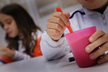 Dos ni&ntilde;os de una familia vulnerable toman la merienda en un local de la Cruz Roja en Sabadell