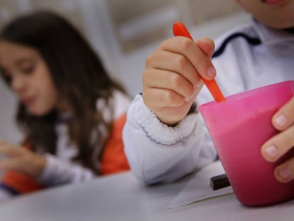 Dos ni&ntilde;os de una familia vulnerable toman la merienda en un local de la Cruz Roja en Sabadell