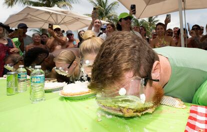 In this photo provided by the Florida Keys News Bureau, Joshua Mogle, right, of Altoona, Iowa, buries his face in a Key lime pie as he eats his way to victory at the World Famous Key Lime Pie Eating Championship Tuesday, July 4, 2023, in Key West, Fla.