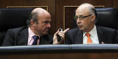 El ministro de Economía, Luis de Guindos, conversa con el ministro de Hacienda, Cristóbal Montoro, en el Congreso.