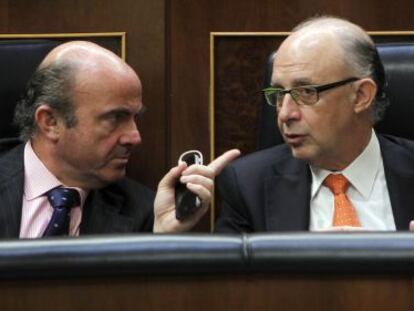 El ministro de Econom&iacute;a, Luis de Guindos, conversa con el ministro de Hacienda, Crist&oacute;bal Montoro, en el Congreso.