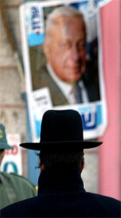 Un judío ortodoxo pasa junto a un cartel electoral de Sharon en Jerusalén.