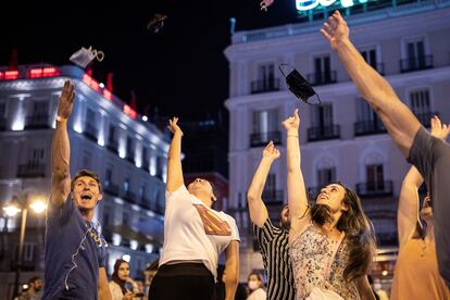 Varias personas celebran el fin del uso obligatorio de la mascarilla en espacios abiertos, el 26 de junio en la Puerta del Sol, en Madrid.