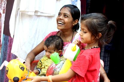 Sunita, una joven de 19 años de Palolem (Goa) juega sonriente con sus sobrinos en la puerta de su tienda de ropa. El sindoor, una marca hecha con un polvo rojo en su frente y pelo la diferencia como casada. Sunita tuvo suerte, su matrimonio con Namu fue un love marriage o matrimonio por amor.  